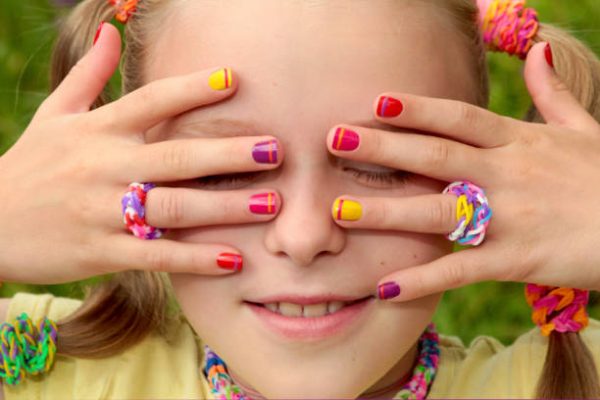 Children's multi-colored manicure with stripes on the girl in the summer.